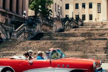Oldtimer fährt an der Universität von Havanna vorbei
